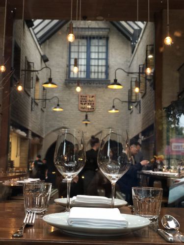 Candlelit restaurant dining room with tall windows and set tables