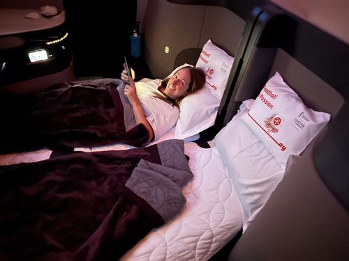 A woman resting in a lie-flat airline seat