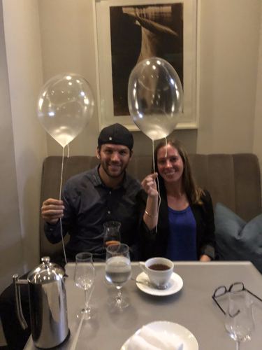 Chase and Allie at a table with balloons, glasses and a pot of tea
