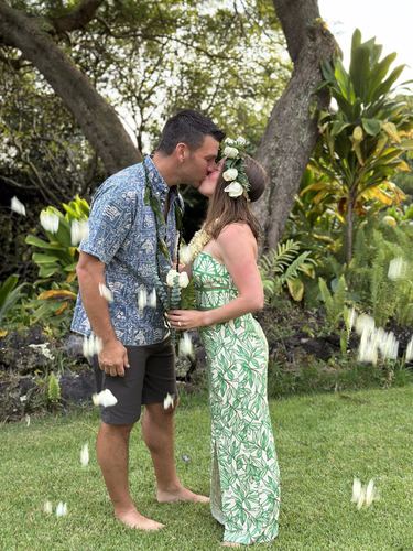 A couple kissing in a garden of tropical flowers