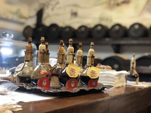 A row of aged balsamic vinegar bottles on a wooden counter