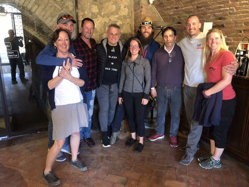 A group of friends posing together in a stone-arched room