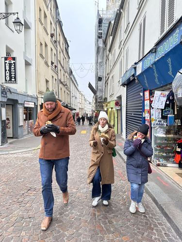 Three people walking down a cobbled street