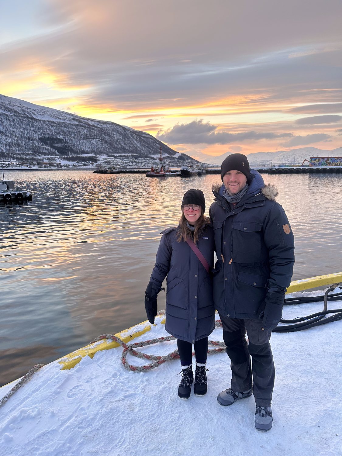 Allie and Chase on a snowy shore at sunset