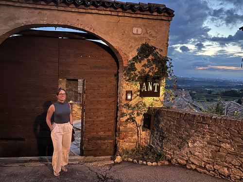 Allie standing in a stone archway beside the “ANT” sign