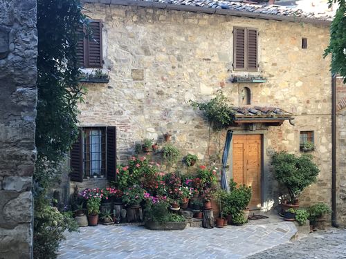 A stone house with a wooden door and pots of flowers
