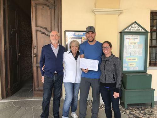 Four people at a church door holding a document