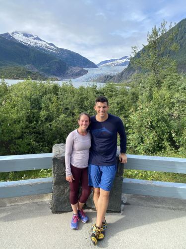 A couple in front of a glacier and snowy mountains