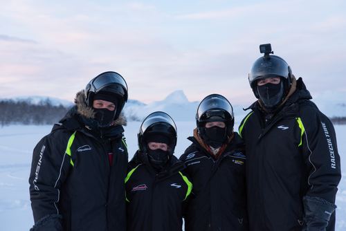 Four people in snowmobile gear