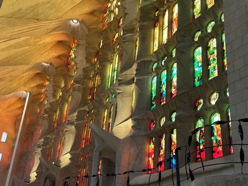 Stained-glass windows lighting the wall inside La Sagrada Familia