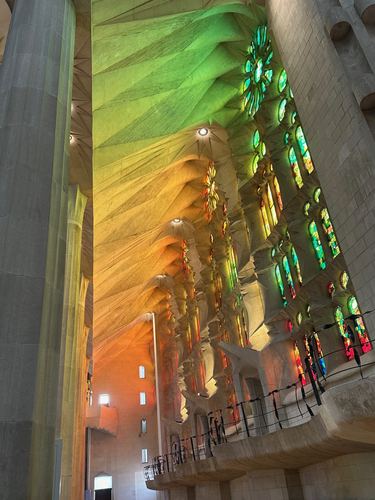 Green and orange light from the stained glass inside La Sagrada Familia
